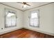 Cozy bedroom featuring hardwood floors, two windows, and a ceiling fan at 301 Colescott St, Shelbyville, IN 46176