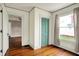 Bedroom with wood floors, vintage wallpaper, window, and entry to another room at 301 Colescott St, Shelbyville, IN 46176