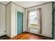 Bedroom with wood floors, vintage wallpaper, window, and built-in teal closet at 301 Colescott St, Shelbyville, IN 46176