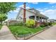 A view of the left side of the home, showcasing the lawn, mature landscaping, and picket fence at 301 Colescott St, Shelbyville, IN 46176