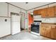 This kitchen features a bright stove, wood cabinets, and vintage appliances at 301 Colescott St, Shelbyville, IN 46176
