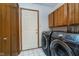Functional laundry room featuring a washer, dryer, cabinets and tile flooring at 3136 River Bay N Dr, Indianapolis, IN 46240