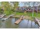 Aerial view of lakefront homes with private docks and boat slips, surrounded by trees at 3136 River Bay N Dr, Indianapolis, IN 46240