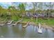 Aerial view of lakefront homes with private docks and boat slips, surrounded by trees at 3136 River Bay N Dr, Indianapolis, IN 46240