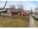 Exterior shot showing the home's red siding, a fenced yard, and a view of the surrounding neighborhood at 3180 Graceland Ave, Indianapolis, IN 46208