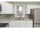 Kitchen featuring stainless steel appliances, white cabinets, granite countertops, and stainless sink at 3180 Graceland Ave, Indianapolis, IN 46208