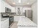 Bright kitchen with white cabinetry, granite countertops, stainless steel appliances, and mosaic backsplash at 3180 Graceland Ave, Indianapolis, IN 46208