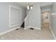 Well-lit living room featuring grey walls, white trim, new laminate flooring, and stairs to the second floor at 3180 Graceland Ave, Indianapolis, IN 46208