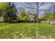 Expansive backyard featuring lush green grass, mature trees, and privacy fencing at 4134 N Pennsylvania St, Indianapolis, IN 46205