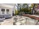 Backyard patio with comfortable outdoor seating, mature trees, and brick accents at 4134 N Pennsylvania St, Indianapolis, IN 46205