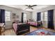 A bright bedroom features two beds, wood floors, multiple windows, and colorful accents and decor at 4134 N Pennsylvania St, Indianapolis, IN 46205