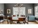 Dining room with a wooden table, chairs, statement lighting and three large windows for natural light at 4134 N Pennsylvania St, Indianapolis, IN 46205