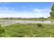 Expansive backyard with a pristine white picket fence enclosing a picturesque pond and grassy lawn at 4264 Amesbury Pl, Noblesville, IN 46062