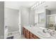 Bright bathroom featuring a double vanity, soaking tub, and glass-enclosed shower at 4264 Amesbury Pl, Noblesville, IN 46062