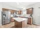 Well-lit kitchen with stainless steel appliances, wooden cabinets, and a center island at 4264 Amesbury Pl, Noblesville, IN 46062
