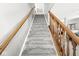This staircase features carpeted steps and wood railings at 4264 Amesbury Pl, Noblesville, IN 46062