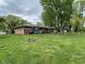 Expansive backyard featuring a well-maintained lawn and mature trees, offering ample space for outdoor activities at 4711 Earlham Dr, Indianapolis, IN 46227