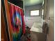 Bathroom featuring vibrant tie dye shower curtain, unique fixtures and wood-look flooring at 4711 Earlham Dr, Indianapolis, IN 46227