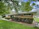 Charming single-story brick home featuring lush greenery, mature trees, and well-maintained landscaping at 4711 Earlham Dr, Indianapolis, IN 46227