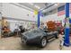 Spacious garage featuring a blue car lift and gray Corvette with the hood up at 5168 E Walnut Dr, Mooresville, IN 46158