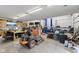 Well-equipped garage featuring tool chests, work bench, car lift, mower, and multiple vehicles at 5168 E Walnut Dr, Mooresville, IN 46158