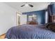 Well-lit main bedroom featuring hardwood floors, dark blue accent walls and a dresser at 5168 E Walnut Dr, Mooresville, IN 46158