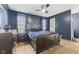 Cozy main bedroom with a ceiling fan, wooden floors, and dark blue walls at 5168 E Walnut Dr, Mooresville, IN 46158