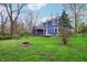 Two-story home with a vibrant blue exterior and a fire pit and a covered patio overlooking the backyard at 524 Deerberry Dr, Noblesville, IN 46062