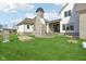 Back exterior of home featuring a stone chimney, patio, grass lawn, and modern design at 579 Exmoor Dr, Carmel, IN 46032