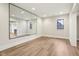 Spacious room with a large mirror, hardwood flooring, white walls, and a window at 579 Exmoor Dr, Carmel, IN 46032