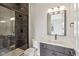 Contemporary bathroom boasts a dark tiled shower, toilet, and a modern vanity with quartz countertops at 579 Exmoor Dr, Carmel, IN 46032