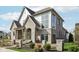 Elegant home showcasing light brick, contrasting white accents, and meticulous landscaping at 579 Exmoor Dr, Carmel, IN 46032