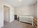 Bright Bedroom featuring a white crib, neutral walls, and a cozy reading nook at 5876 E 126Th St, Carmel, IN 46033