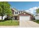Charming two-story home featuring a brick facade, white siding, and a spacious two-car garage at 5876 E 126Th St, Carmel, IN 46033