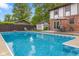 Inviting backyard featuring a sparkling pool, patio seating, and mature trees, ideal for relaxation and outdoor gatherings at 601 Ridgeview Ln, Columbus, IN 47201