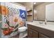 Neutral bathroom with a patterned shower curtain and a brown vanity with a white sink, complimented by matching brown shelves at 601 Ridgeview Ln, Columbus, IN 47201