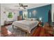 Primary bedroom with blue accent wall, windows, ceiling fan and wood floors at 601 Ridgeview Ln, Columbus, IN 47201