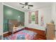 Cozy bedroom with a two-tone green and white color scheme, a crib, complemented by bright and colorful decor at 601 Ridgeview Ln, Columbus, IN 47201