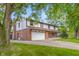 Charming two-story Tudor-style home featuring a brick facade, attached two-car garage, and mature landscaping at 601 Ridgeview Ln, Columbus, IN 47201