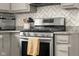 Close-up of the kitchen showcasing the stainless steel stove, herringbone backsplash, and modern cabinetry at 601 Ridgeview Ln, Columbus, IN 47201
