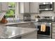 Stylish kitchen with stainless steel appliances, gray cabinets, and herringbone backsplash, offering a contemporary design at 601 Ridgeview Ln, Columbus, IN 47201