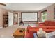 Living room featuring a large projection screen, comfortable red seating, and natural light creating an inviting entertainment space at 601 Ridgeview Ln, Columbus, IN 47201