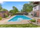 Sparkling in-ground pool with lounge chairs, patio seating, and lush landscaping in a private backyard oasis at 601 Ridgeview Ln, Columbus, IN 47201