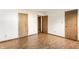 Empty bedroom with wood floors, three doors, and white walls at 6140 King Lear Ln, Indianapolis, IN 46254