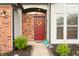 Charming red front door with decorative wreath and brick accents at 6140 King Lear Ln, Indianapolis, IN 46254