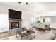 Open living room and dining area with a fireplace, hardwood floors, and comfortable seating at 6140 King Lear Ln, Indianapolis, IN 46254