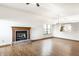 Open living room with a fireplace and hardwood floors, next to a partial view of the kitchen at 6140 King Lear Ln, Indianapolis, IN 46254
