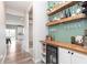 Stylish home bar area featuring custom shelving, a wine refrigerator, and elegant glassware displays for entertaining guests at 6164 Brighton Dr, Whitestown, IN 46075