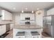 Open kitchen with white cabinets, a gray center island with seating, stainless steel appliances, and modern pendant lighting at 6164 Brighton Dr, Whitestown, IN 46075