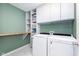 Bright laundry room with built-in cabinets, shelving, wooden countertop, and modern Whirlpool washer and dryer at 6164 Brighton Dr, Whitestown, IN 46075